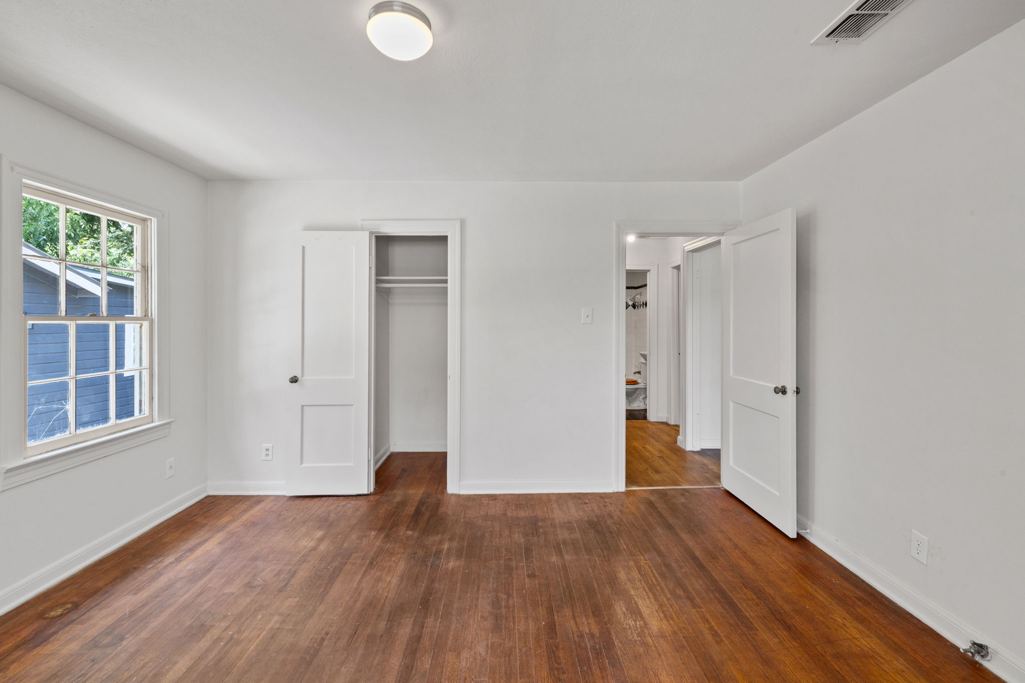 3704 Cherrywood Road Austin, TX 78722 - Photo 27 of 40 A quiet bedroom featuring hardwood flooring and a functional closet.
