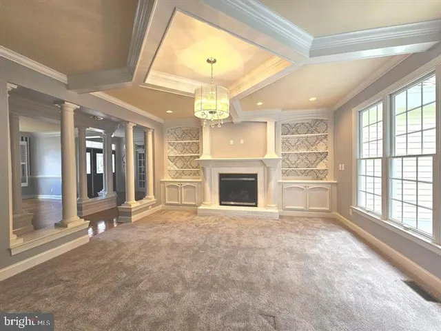 a view of an empty room with a fireplace and a window