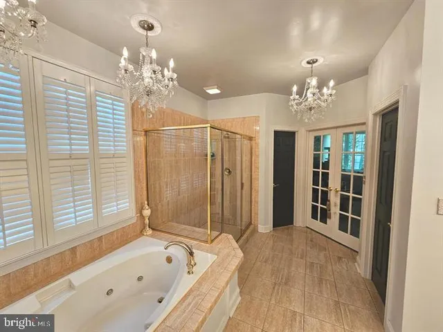 a spacious bathroom with a tub shower and chandelier