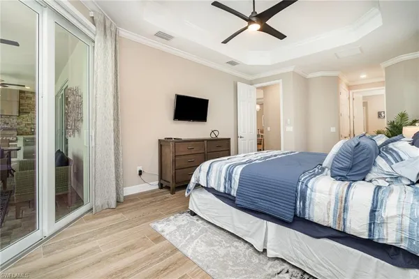 a bedroom with a large bed a flat tv screen and a walk in closet