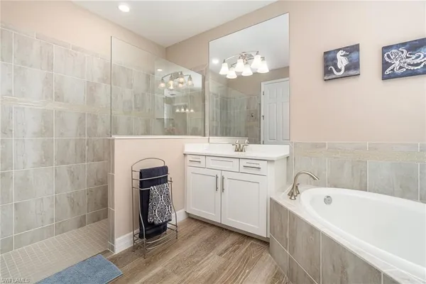 a bathroom with a double vanity sink a mirror a bathtub and shower