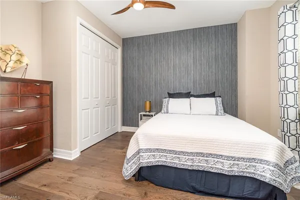 a large bed sitting in a bedroom next to a window and dresser