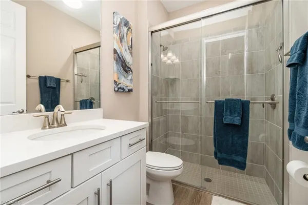 a bathroom with a sink a toilet and shower