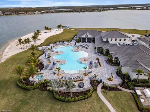 an aerial view of a house with a swimming pool a yard and a fire pit