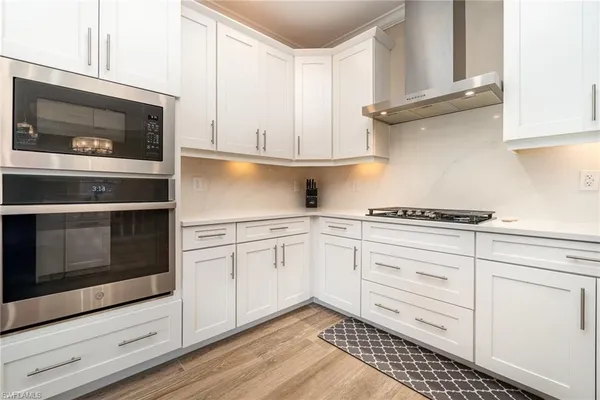 a kitchen with granite countertop white cabinets and appliances
