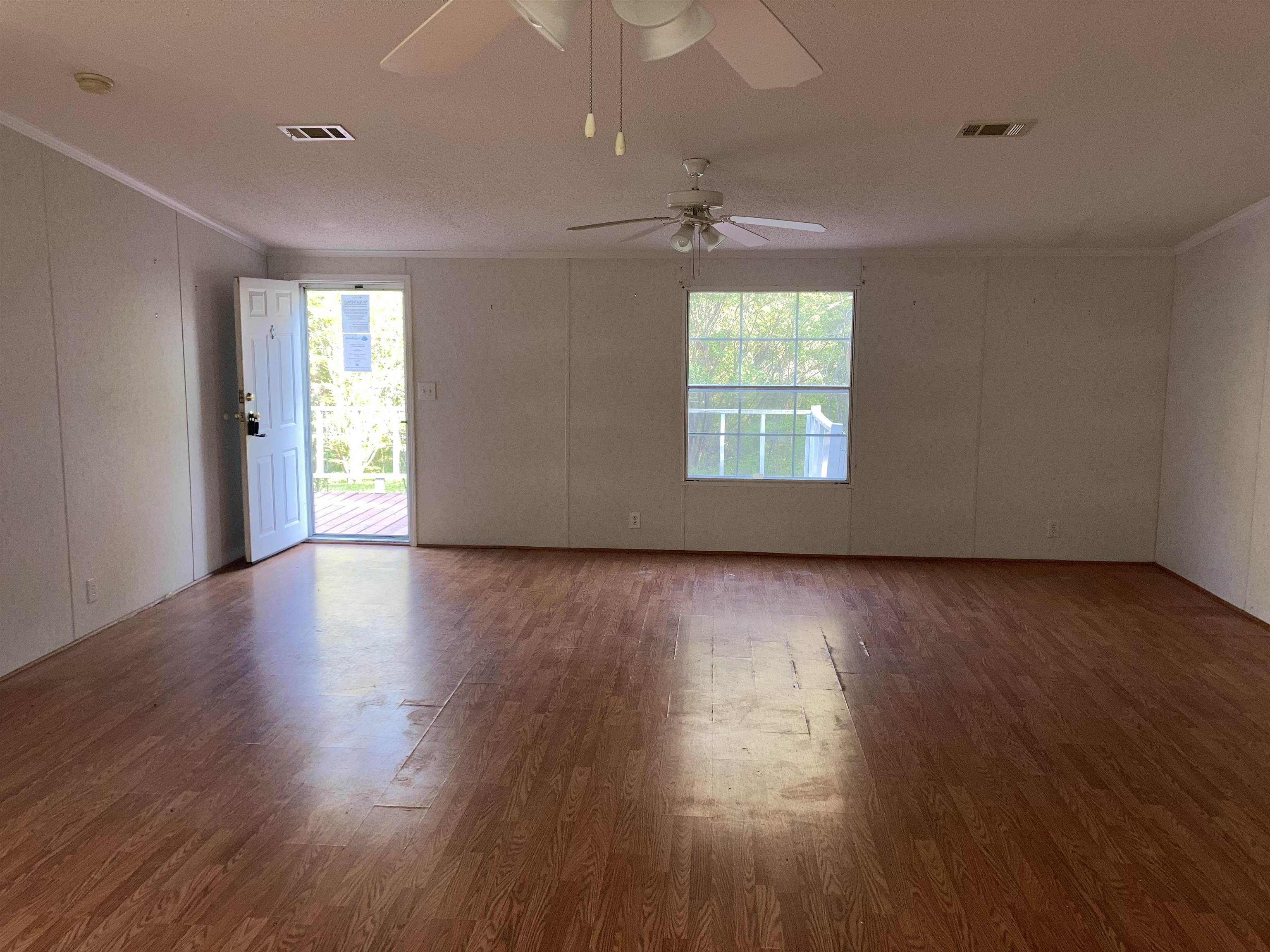 840 Rose Road Somerville, TN 38068 - Photo 11 of 21 Spare room featuring crown molding, wood finished floors, healthy amount of natural light, and a decorative wall