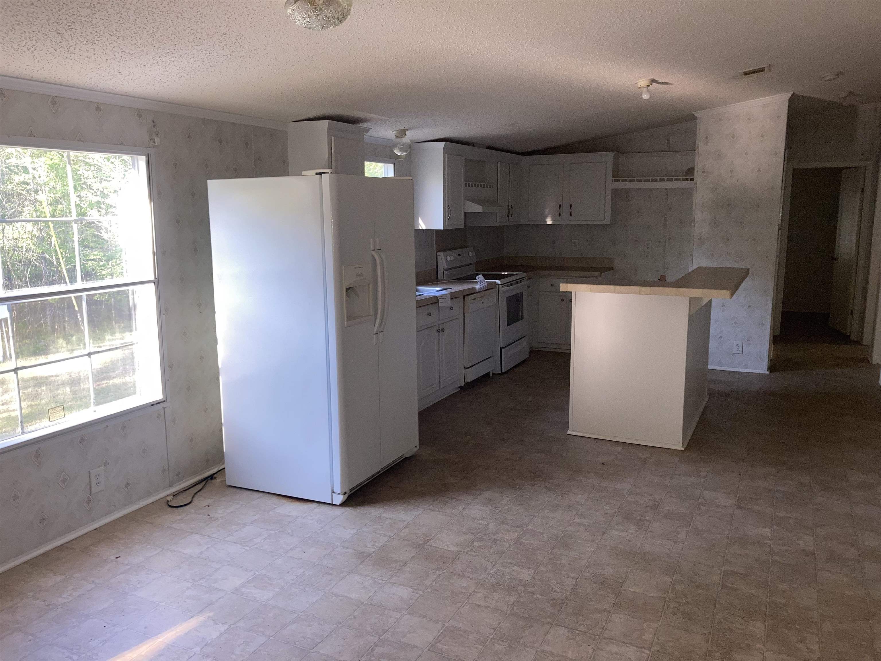 840 Rose Road Somerville, TN 38068 - Photo 12 of 21 Kitchen featuring wallpapered walls, white appliances, light floors, light countertops, and white cabinetry