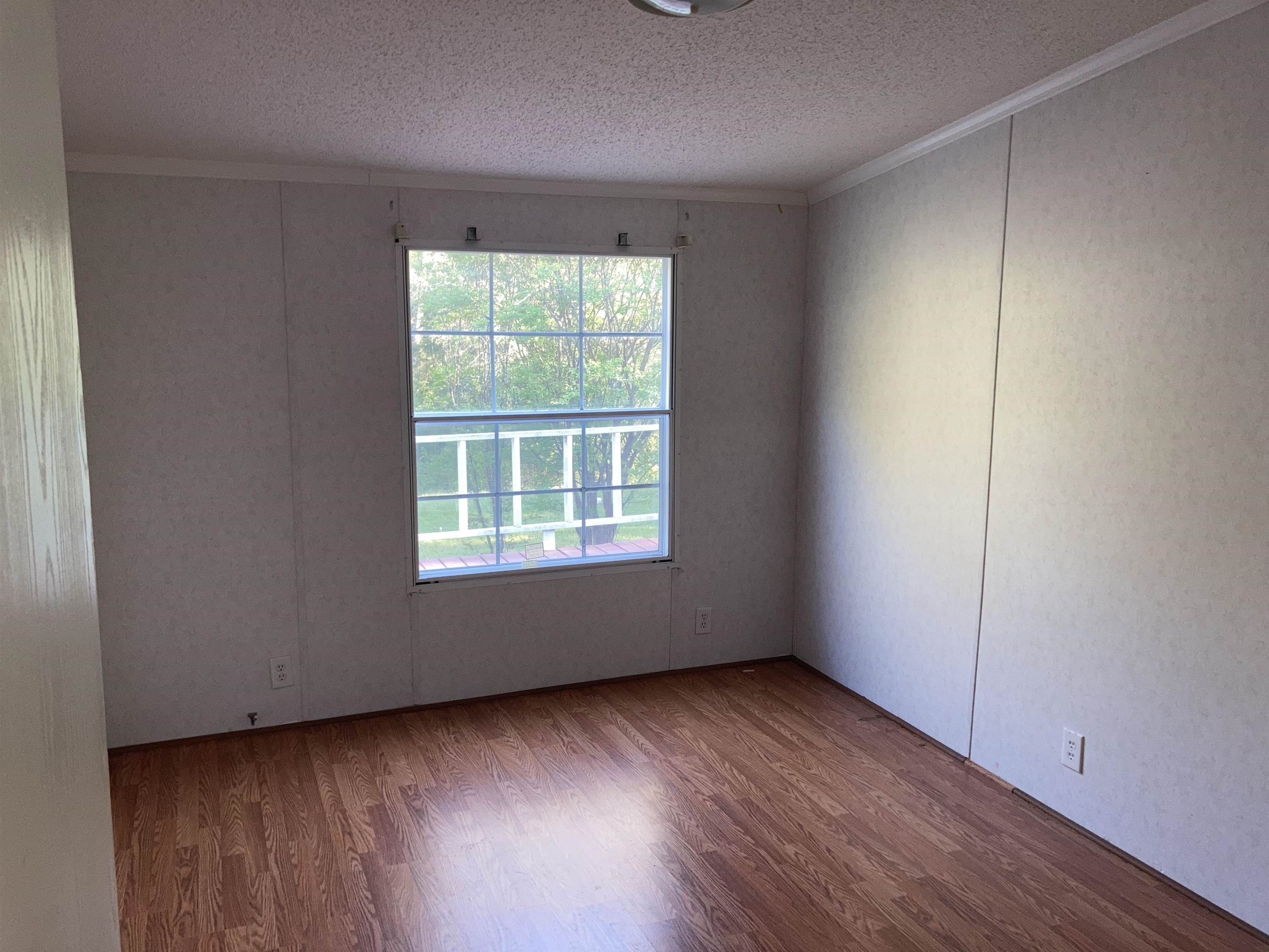 840 Rose Road Somerville, TN 38068 - Photo 15 of 21 Unfurnished room featuring wood finished floors, a textured ceiling, and ornamental molding