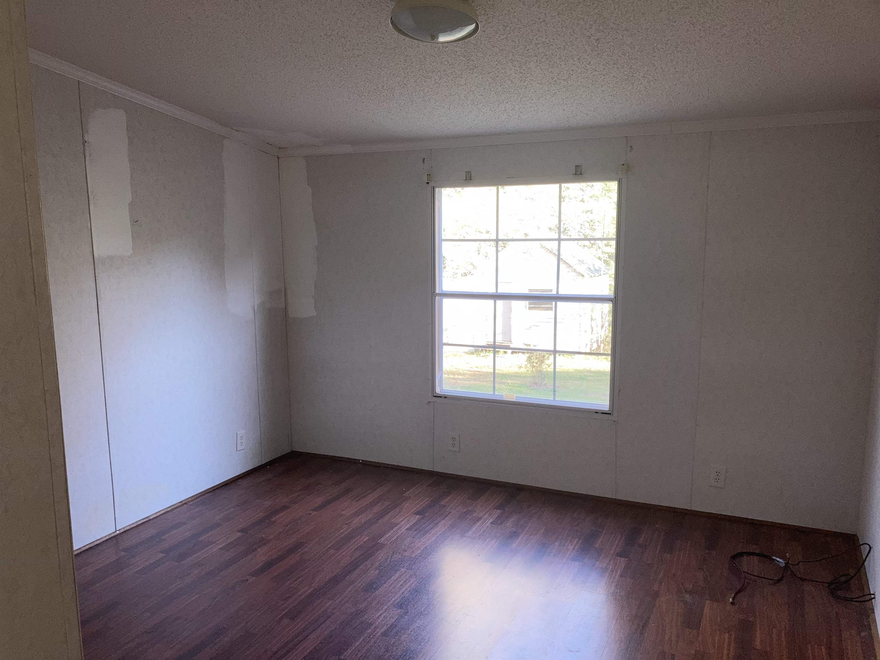840 Rose Road Somerville, TN 38068 - Photo 17 of 21 Spare room with dark wood-style floors, a textured ceiling, and crown molding