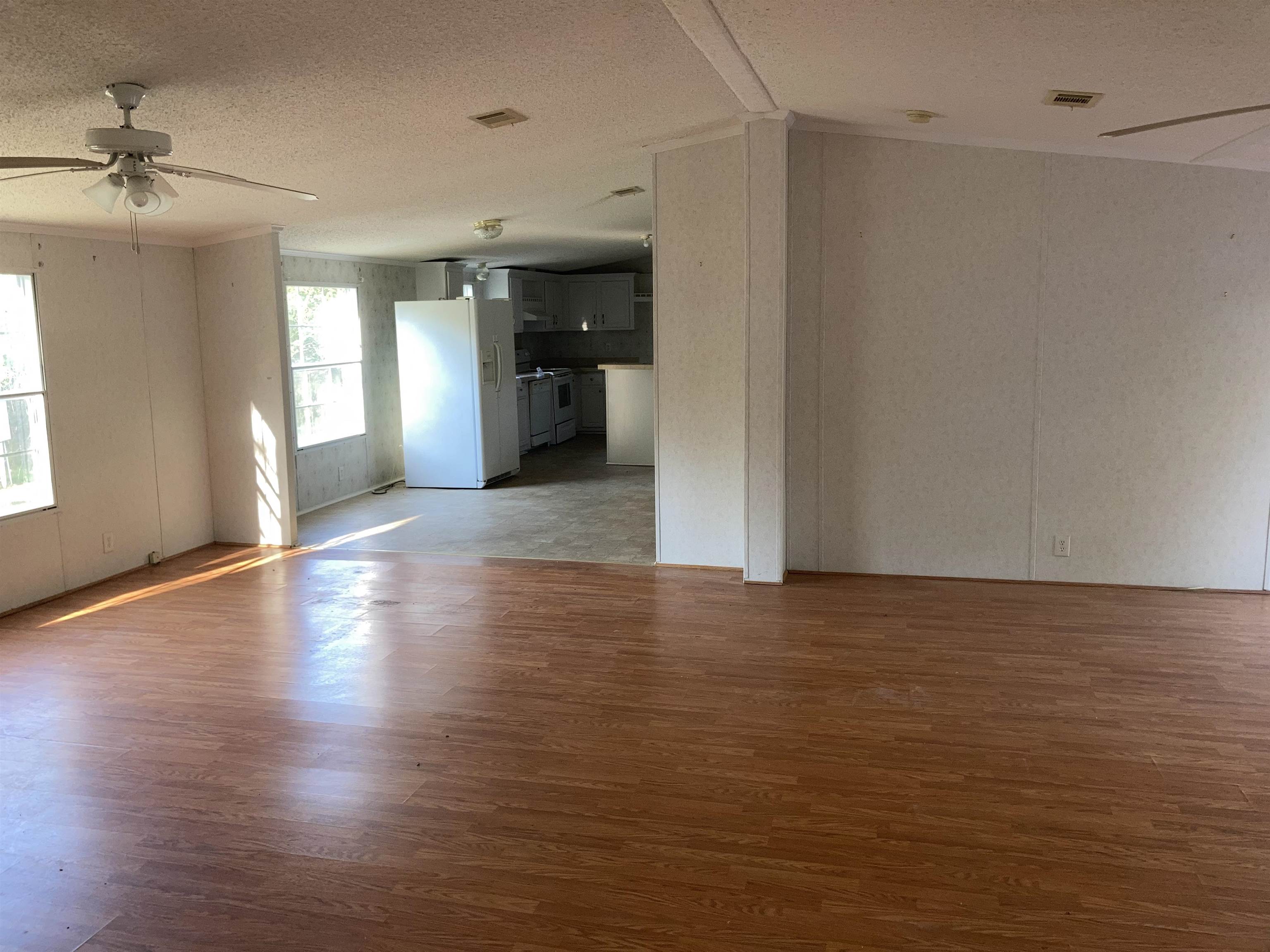 840 Rose Road Somerville, TN 38068 - Photo 10 of 21 Unfurnished living room with ceiling fan, a textured ceiling, and dark wood-style flooring