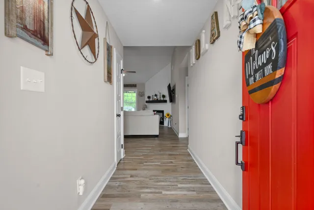 a view of a hallway with wooden floor and staircase