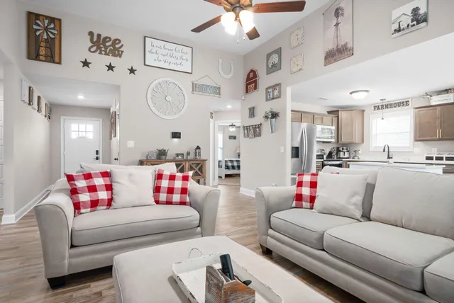 a living room with furniture and a view of kitchen