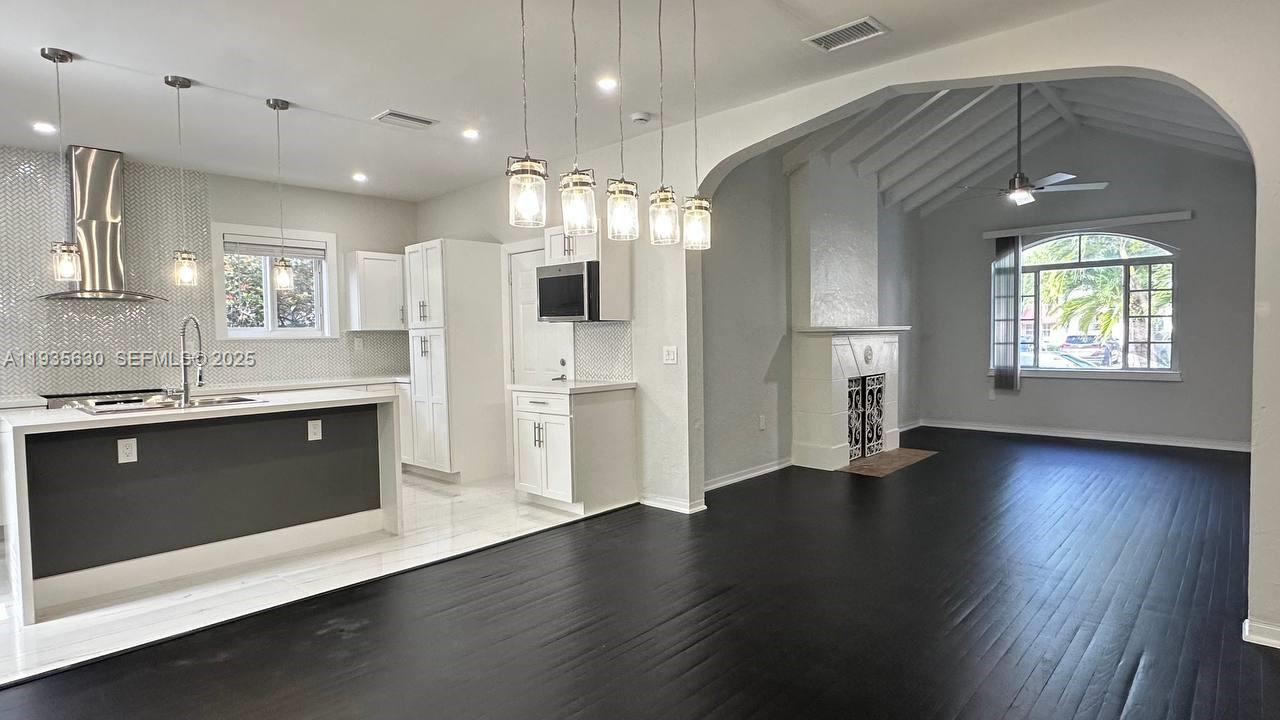 1824 Southwest 24th Street Miami, FL 33145 - Photo 4 of 35 a large kitchen with stainless steel appliances a large counter top a sink a refrigerator and a window