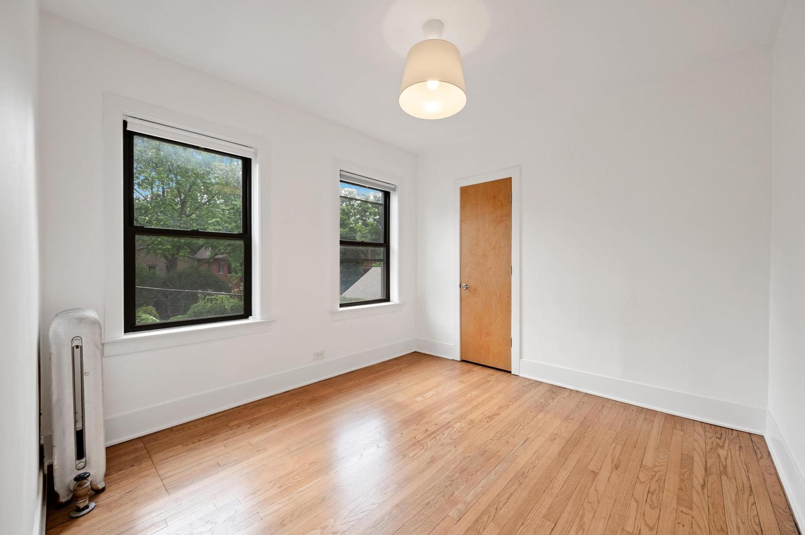 5469 South Ingleside Avenue, Unit 2N Chicago, IL 60615 - Photo 11 of 15 an empty room with wooden floor and windows