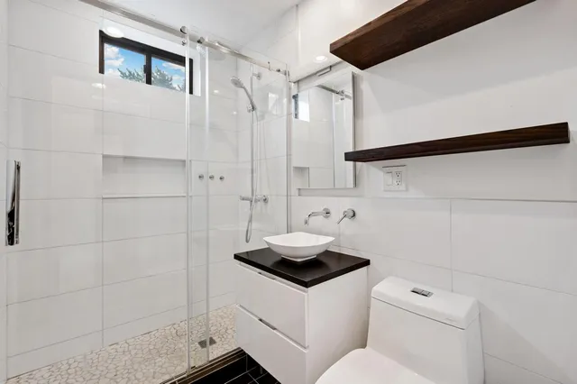 a bathroom with a sink a toilet and shower