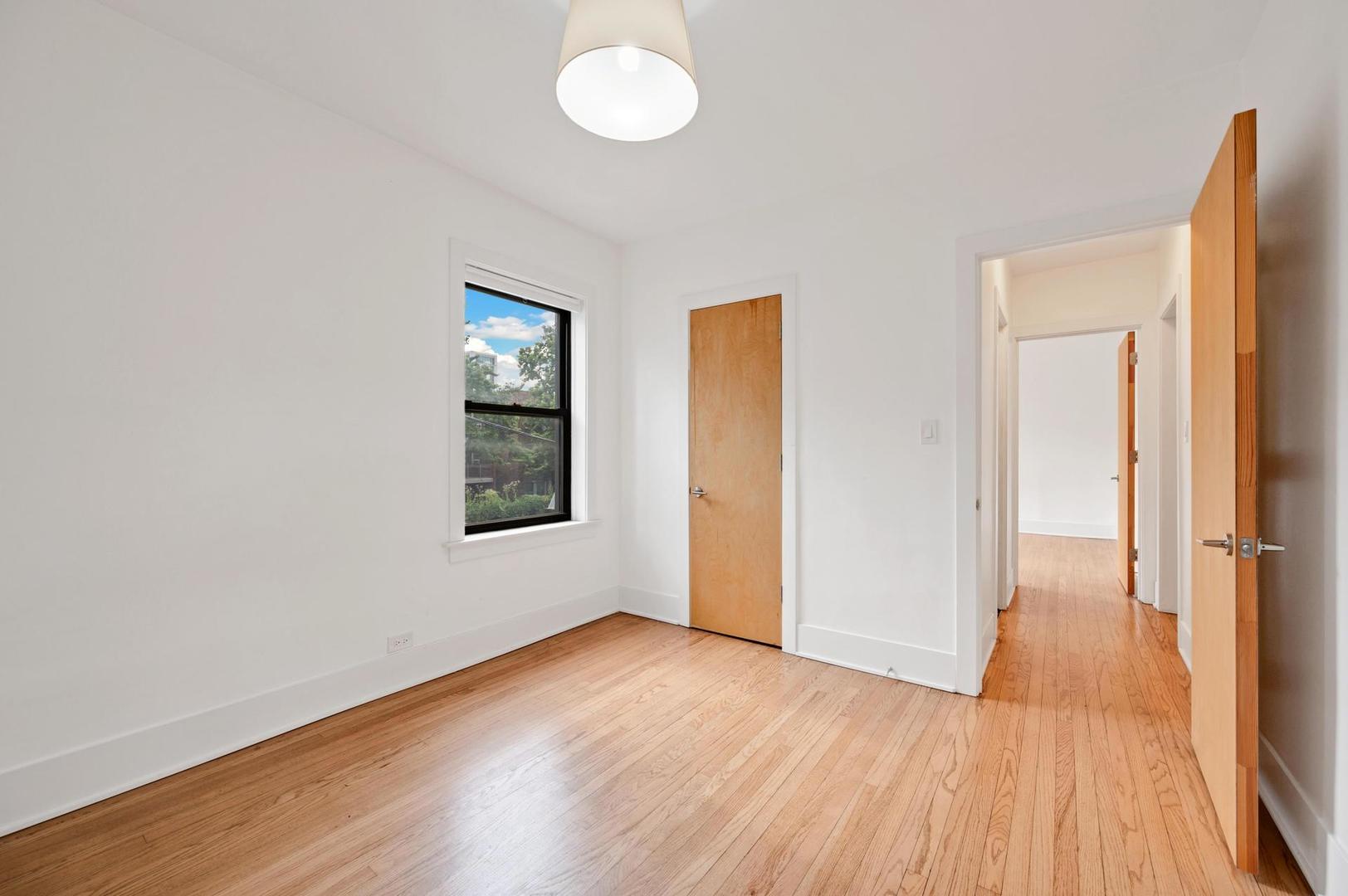 5469 South Ingleside Avenue, Unit 2N Chicago, IL 60615 - Photo 8 of 15 an empty room with wooden floor and windows