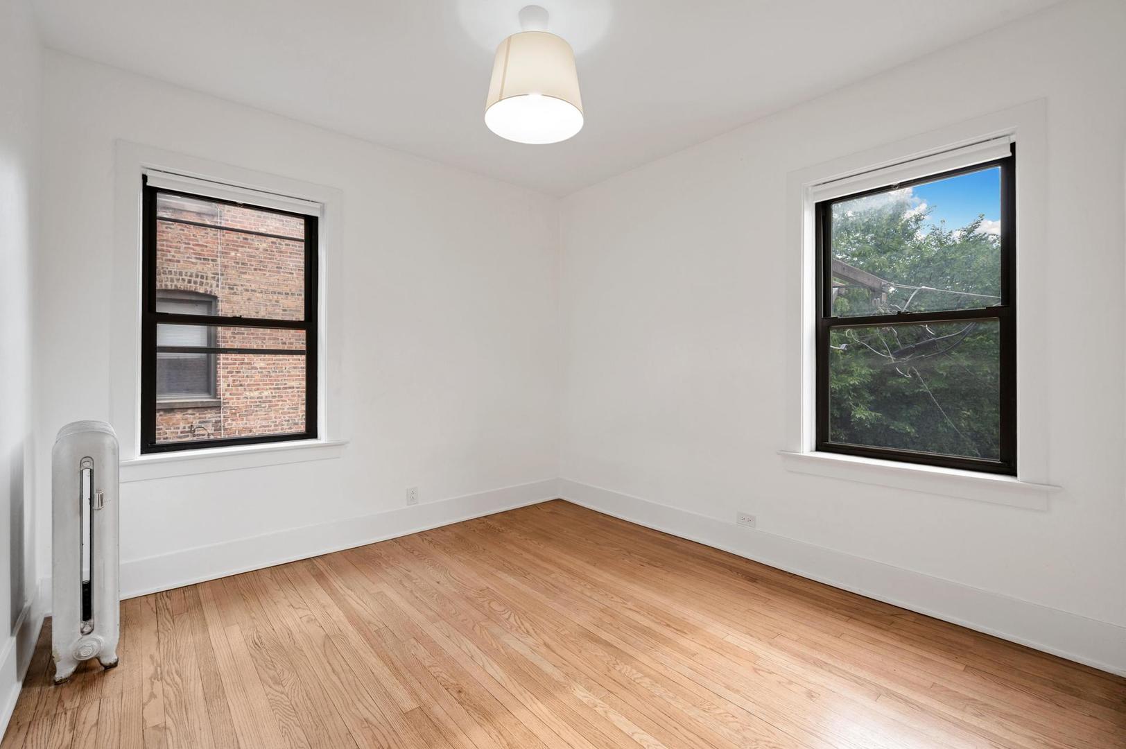 5469 South Ingleside Avenue, Unit 2N Chicago, IL 60615 - Photo 9 of 15 an empty room with wooden floor and windows