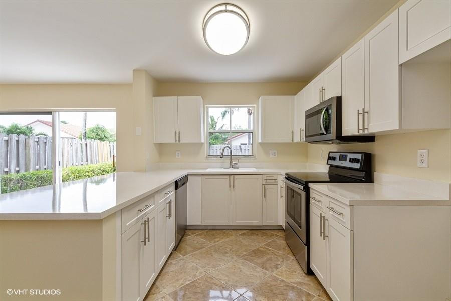 7463 Viscaya Circle Margate, FL 33063 - Photo 7 of 22 a kitchen with cabinets appliances a sink and a window