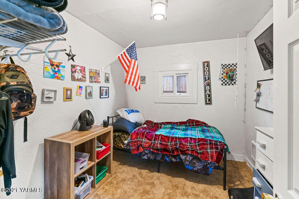 10710 Hughes Road Yakima, WA 98903 - Photo 14 of 21 a bedroom with baby bed and a window