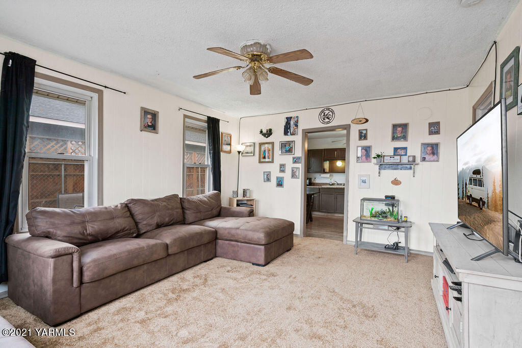 10710 Hughes Road Yakima, WA 98903 - Photo 4 of 21 a living room with furniture flat screen tv and a fireplace
