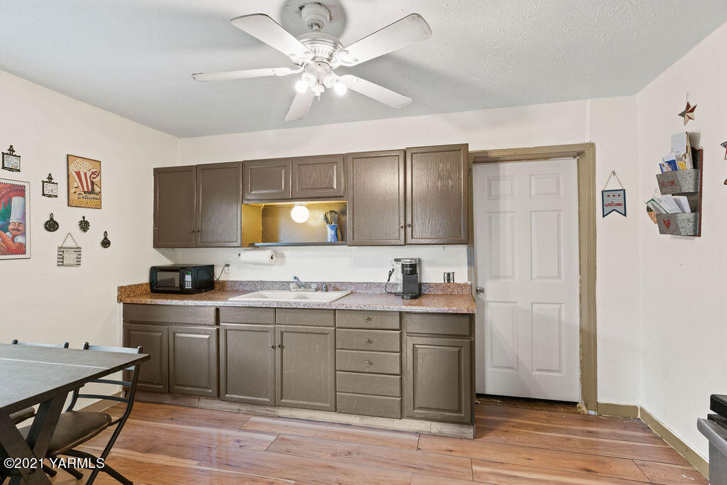 10710 Hughes Road Yakima, WA 98903 - Photo 5 of 21 a kitchen with a sink cabinets and wooden floor