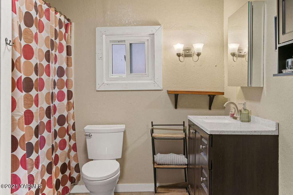 10710 Hughes Road Yakima, WA 98903 - Photo 10 of 21 a bathroom with a toilet a sink and a mirror