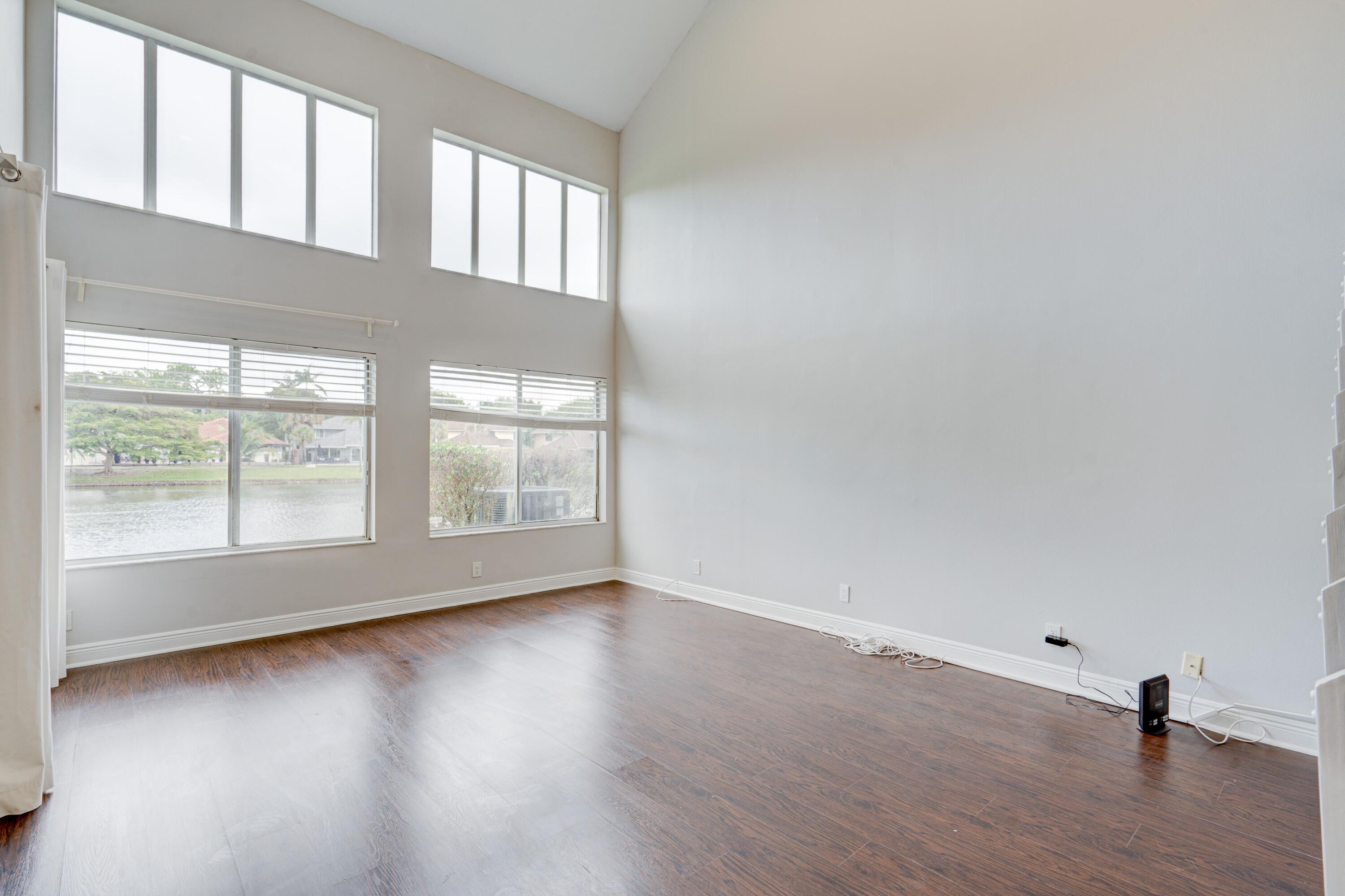 6663 Boca Pines Trail, Unit A Boca Raton, FL 33433 - Photo 28 of 60 a view of an empty room with wooden floor and a window