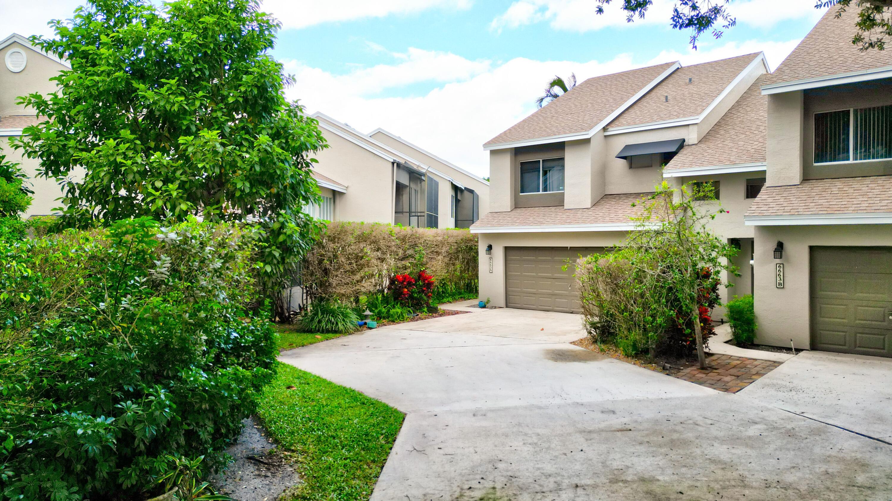 6663 Boca Pines Trail, Unit A Boca Raton, FL 33433 - Photo 3 of 60 a front view of a house with a yard and garage