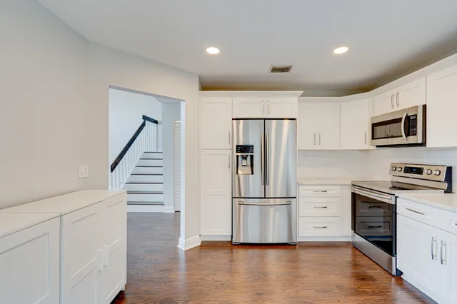 an empty room with wooden floor and ceiling fan