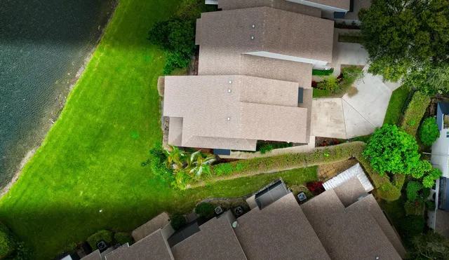 an aerial view of residential houses with outdoor space and trees