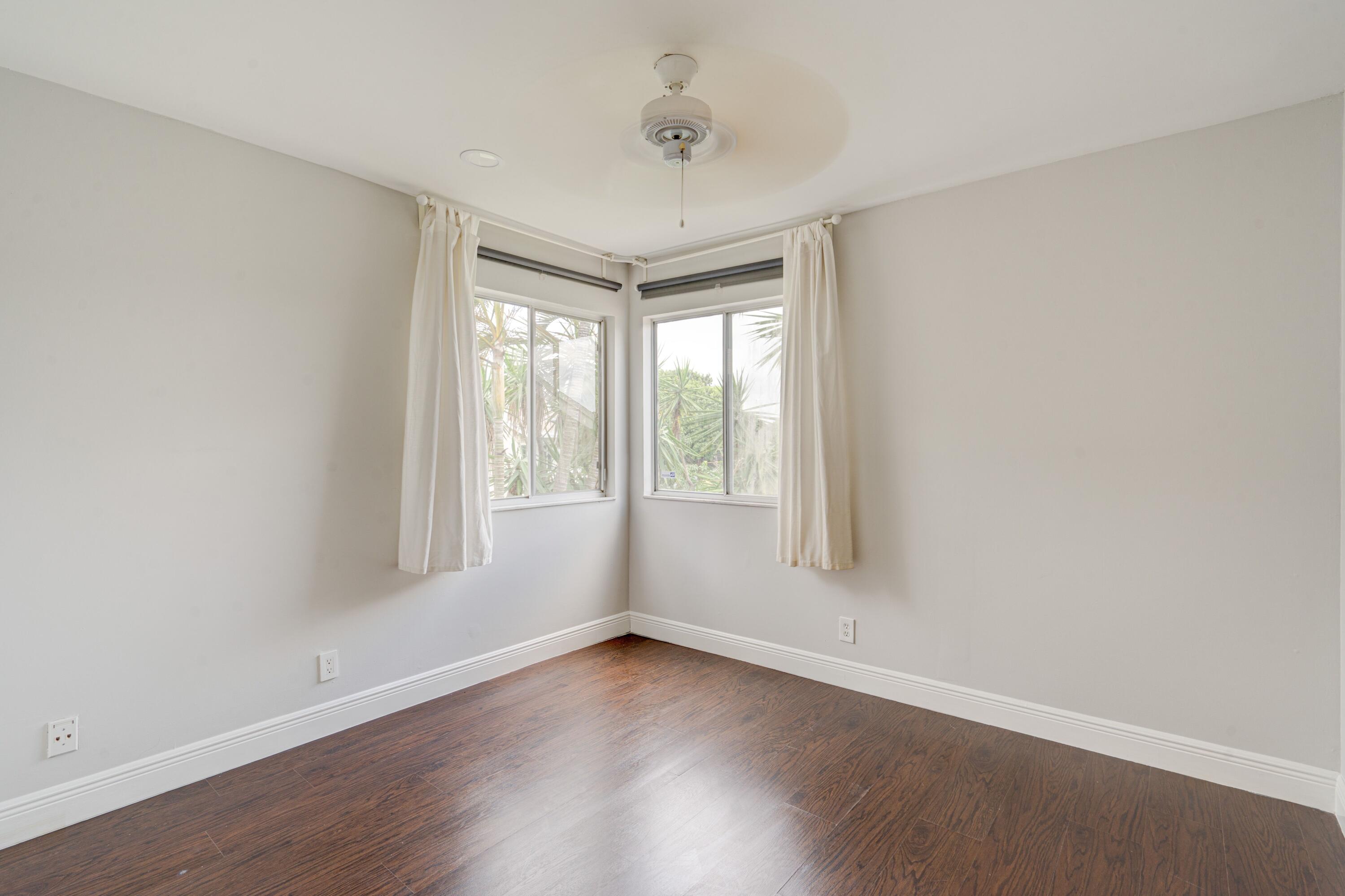 6663 Boca Pines Trail, Unit A Boca Raton, FL 33433 - Photo 46 of 60 an empty room with wooden floor and windows