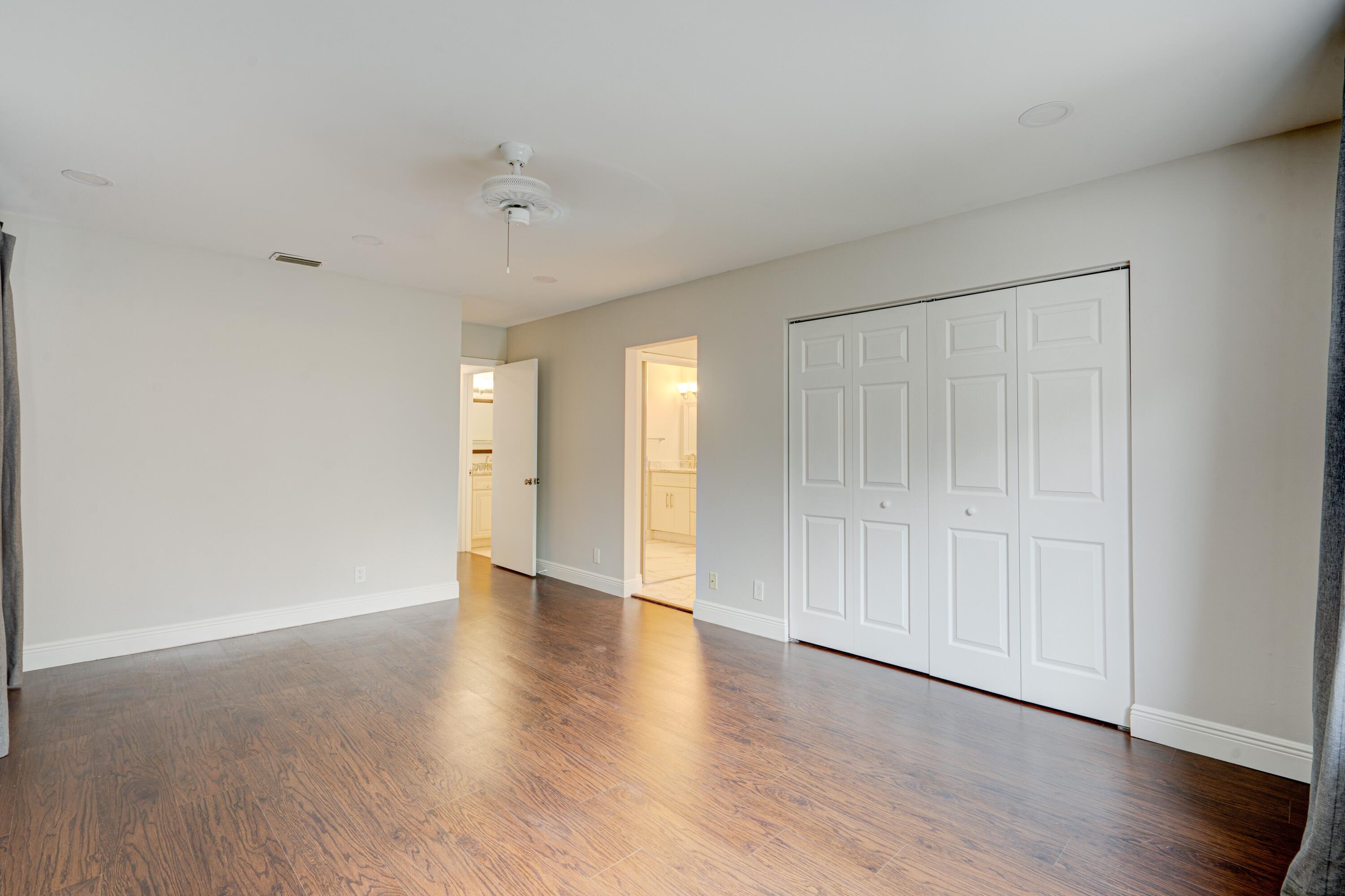 6663 Boca Pines Trail, Unit A Boca Raton, FL 33433 - Photo 54 of 60 a view of an empty room with wooden floor and a window