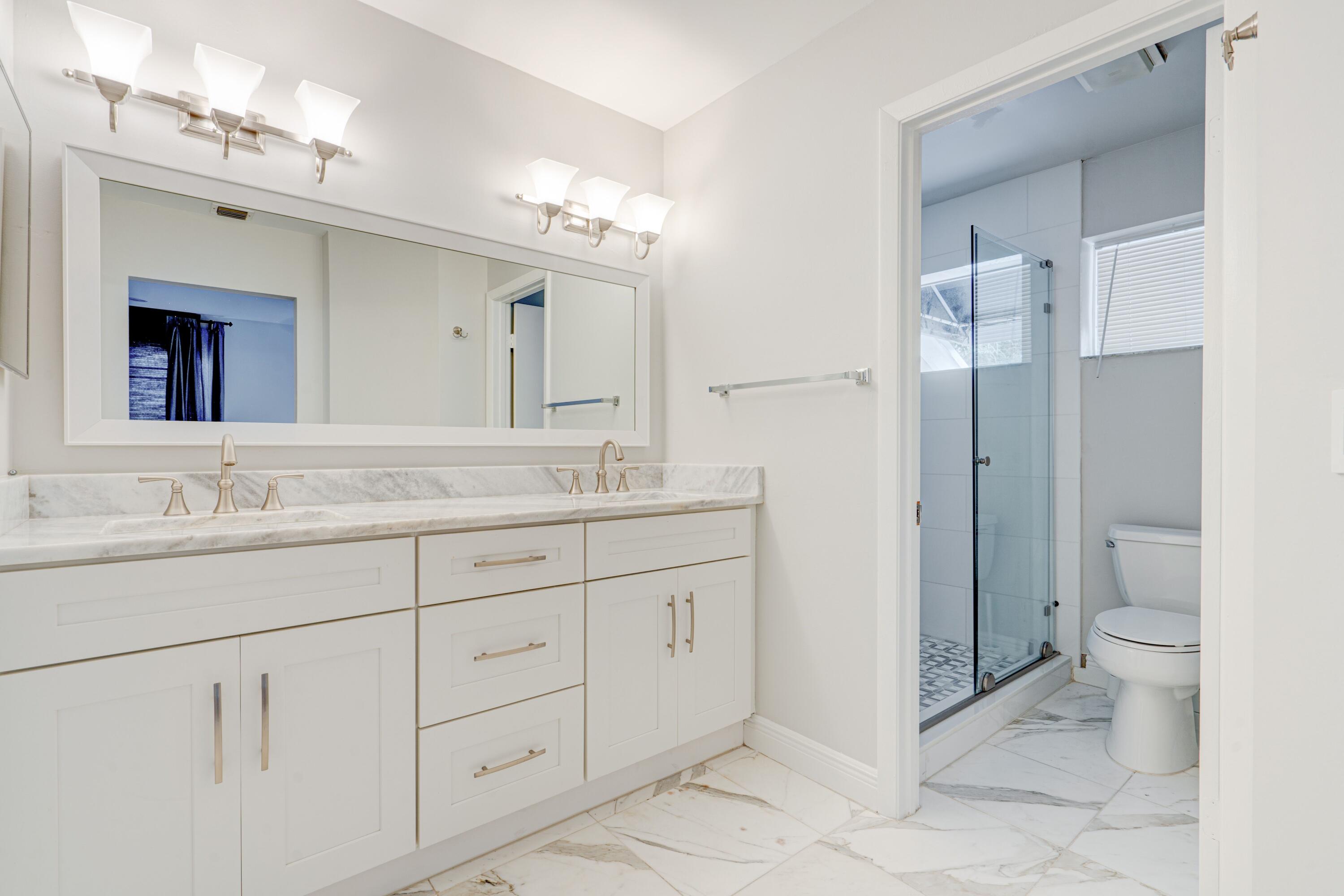 6663 Boca Pines Trail, Unit A Boca Raton, FL 33433 - Photo 56 of 60 a bathroom with a granite countertop sink toilet and shower