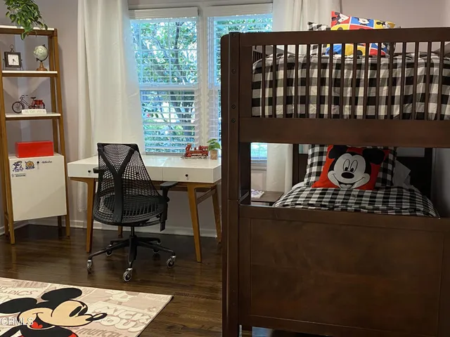 a black leather chair sitting in a bedroom next to a window