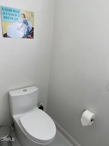 a white toilet sitting next to a white wall