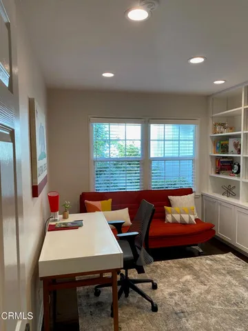 a living room with furniture a table and a large window