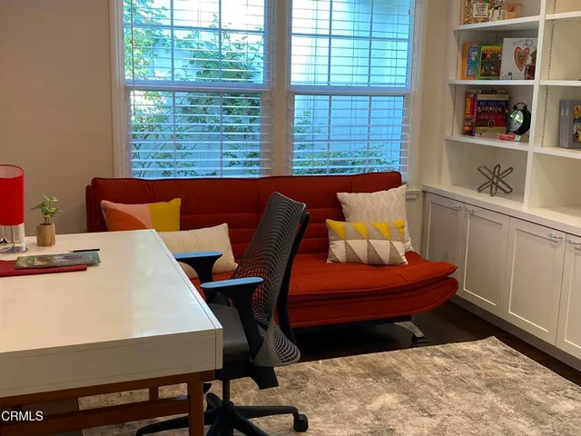 a bedroom with a bed and dresser next to a window