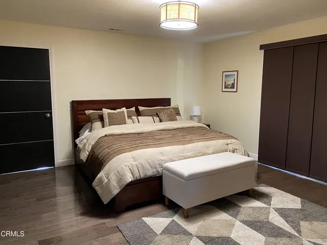 a bed sitting in a bedroom next to a wooden cabinet