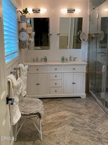 a spacious bathroom with a double vanity sink mirror and shower