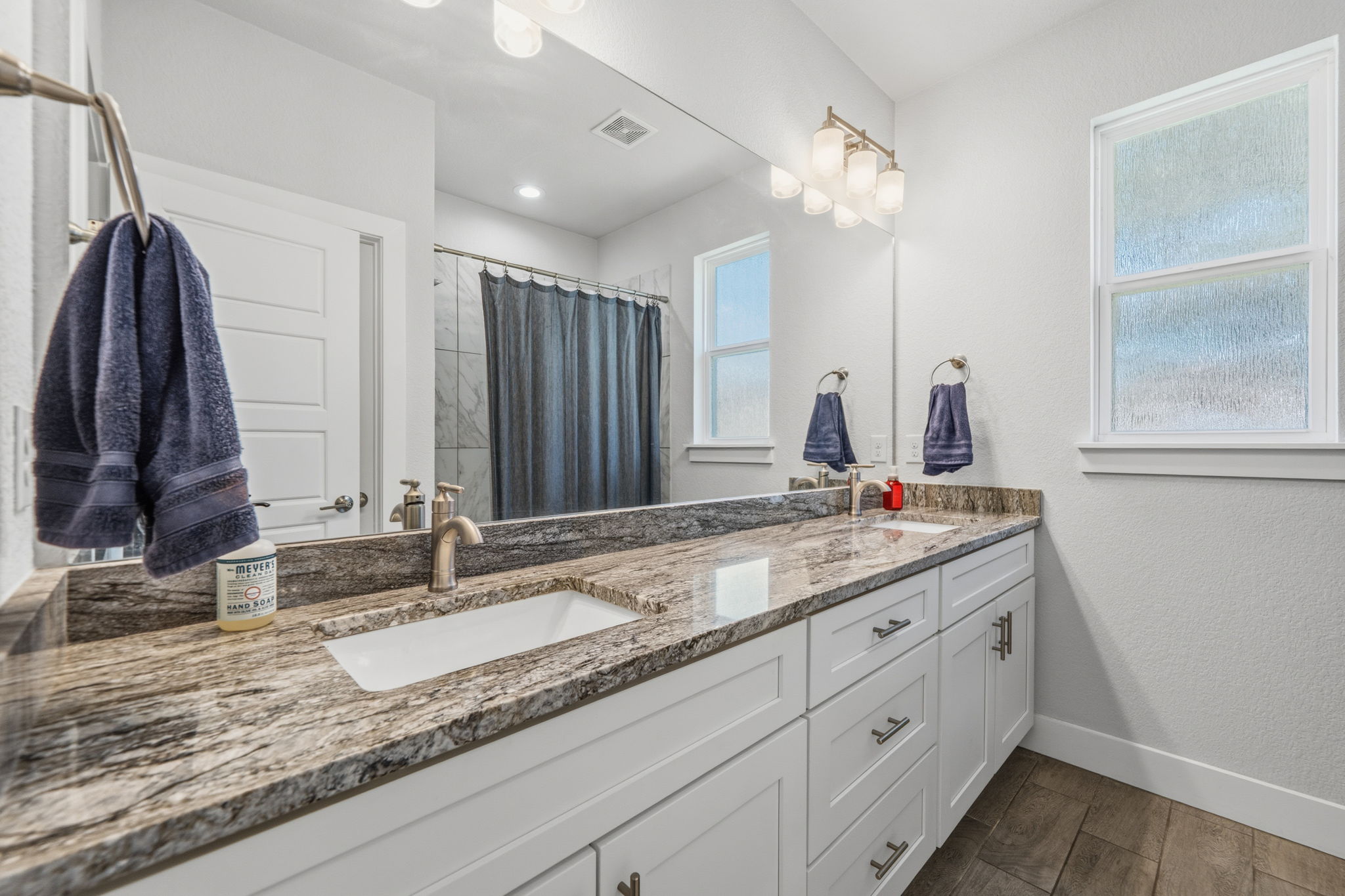 18605 Masters Cove Point Venture, TX 78645 - Photo 22 of 40 Double vanity with integrated sinks, granite countertops, white shaker cabinetry, and brushed nickel hardware