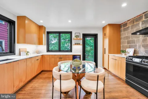 a kitchen with stainless steel appliances granite countertop a kitchen island hardwood floor sink stove and granite counter top
