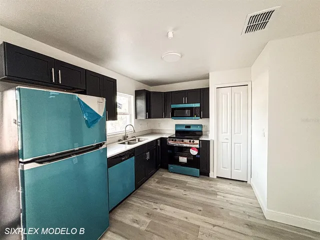 a kitchen with stainless steel appliances granite countertop a refrigerator and a sink