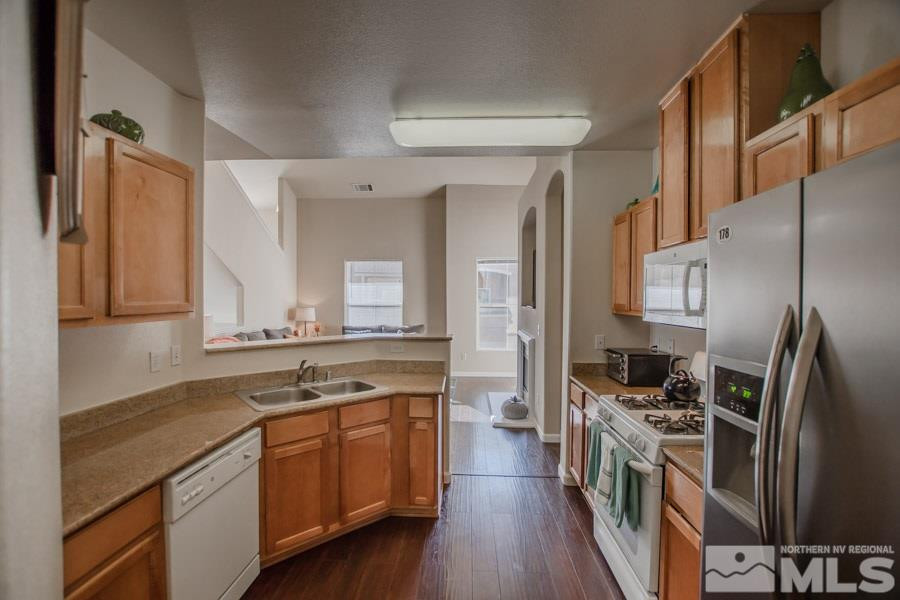9050 Double R Boulevard, Unit NV Reno, NV 89521 - Photo 11 of 25 a kitchen with stainless steel appliances granite countertop a sink stove and refrigerator