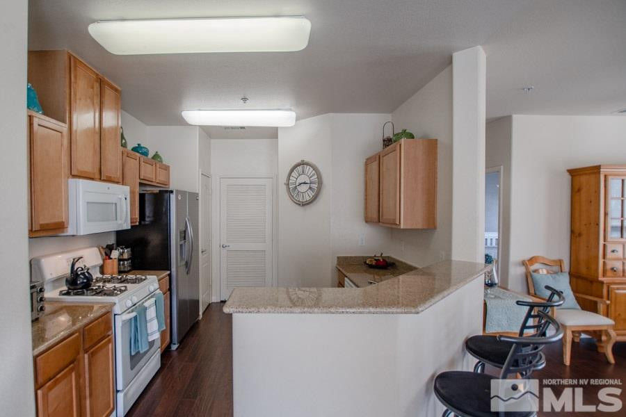 9050 Double R Boulevard, Unit NV Reno, NV 89521 - Photo 12 of 25 a kitchen with granite countertop a sink stove and refrigerator
