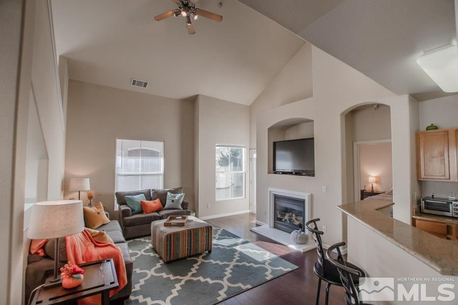 9050 Double R Boulevard, Unit NV Reno, NV 89521 - Photo 6 of 25 a living room with furniture a flat screen tv and a fireplace