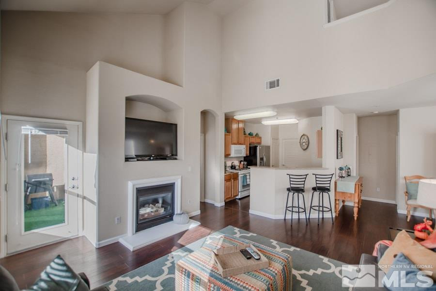 9050 Double R Boulevard, Unit NV Reno, NV 89521 - Photo 7 of 25 a living room with furniture a flat screen tv and a fireplace