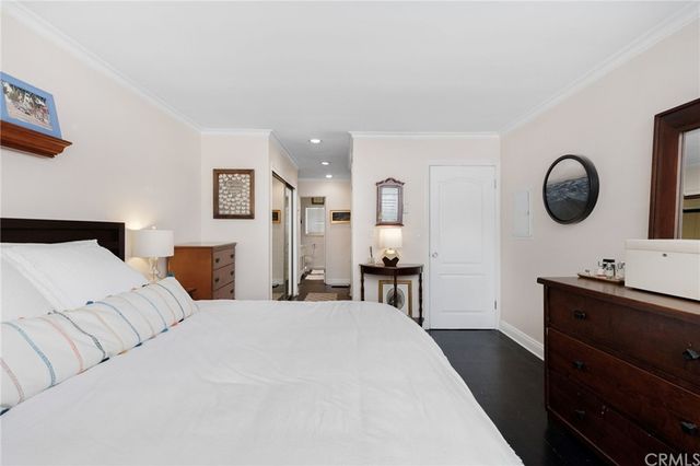 a bed room with a bed mirror and a chair