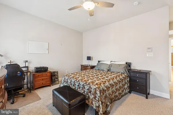 a front view of a building with lot of cars and trees