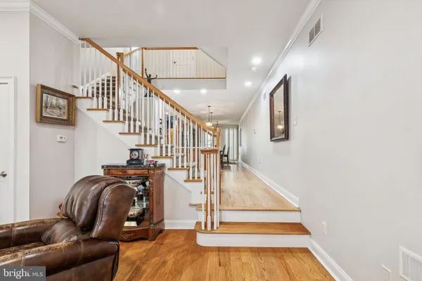 a kitchen with stainless steel appliances kitchen island granite countertop a refrigerator a stove and a sink with wooden floor