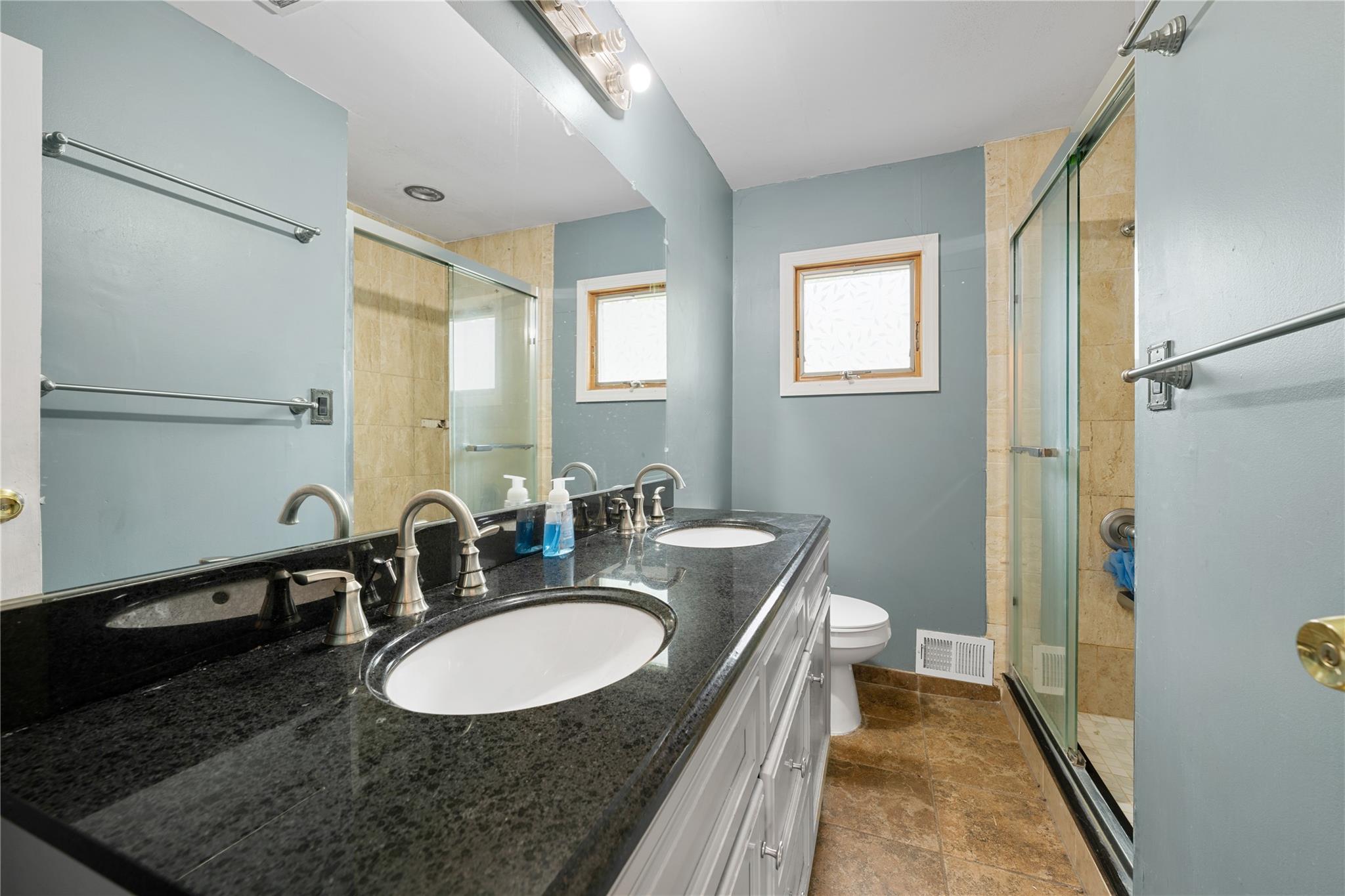 51 Joline Road Port Jefferson Station, NY 11776 - Photo 23 of 38 a bathroom with a granite countertop sink a mirror a vanity and a shower